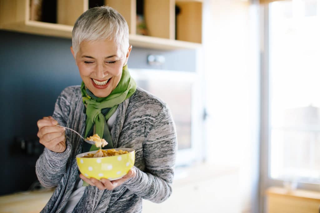 Mature woman having healthy beakfast. Shallow DOF. Developed from RAW; retouched with special care and attention; Small amount of grain added for best final impression. 16 bit Adobe RGB color profile.